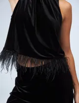 Conjunto de musculosa y pantalón en terciopelo negro, marca Julia Jordan. Blusa de cuello alto y terminación de ruedo con plumas. Pantalón con cintura elastizada.