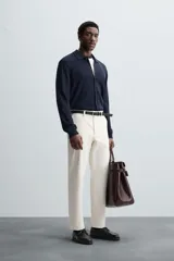 Pantalón chino de vestir negro, corte slim fit, con bolsillos laterales y traseros. Cierre frontal con cremallera y botón.