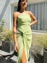 Vestido largo lila con escote halter cruzado en la espalda y falda tipo pareo con abertura lateral y nudo decorativo.