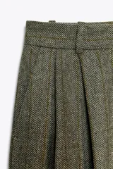Pantalón de tiro alto con bolsillos delanteros, pinzas y cierre frontal con cremallera y gancho metálico.