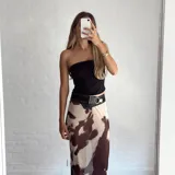 Pollera larga de microtul con estampado de vaca en tonos marrones y beige. Tiene elástico en la cintura y es transparente.