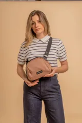 Bandolera pequeña de tela negra, con correa ancha ajustable y cierre superior.