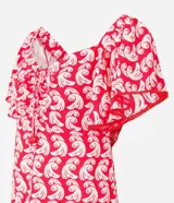 Vestido corto de viscosa y lino con estampado de olas en color blanco sobre fondo rojo. Tiene escote off-shoulder, mangas cortas holgadas, lazo en el busto con detalle de abalorios y volado en el bajo.