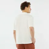 Camisa de manga corta color blanco hueso, de tejido calado con cuello solapa y bolsillo de parche en el pecho.