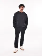 Buzo deportivo negro de corte regular, con cuello redondo y mangas largas.