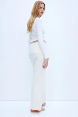 Pantalón de punto color crema, de pierna ancha y cintura alta con detalle drapeado.