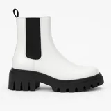 Bota Chelsea blanca de cuero sintético con elásticos laterales negros y suela track negra.