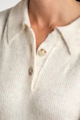 Sweater de tejido de punto grueso, color marrón y azul marino, con diseño de rayas horizontales anchas. Presenta cuello polo y abertura frontal con dos botones nacarados.