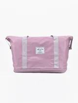 Bolso de viaje plegable color lila con asas plateadas.
