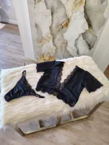 Conjunto negro de lycra, microtul y encaje suave elastizado. Incluye top con broche de gancho y espalda de microtul con detalles de encaje, y tanga regulable con forro de algodón.