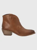 Botín de cuero metalizado color peltre, con puntera fina, laterales con diseño estilo cowboy y taco bajo.
