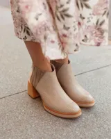 Botas cortas color beige con textura de reptil, taco de madera y detalle de elástico en los laterales.