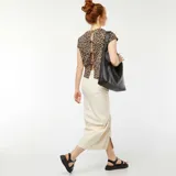Camiseta beige con estampado animal print de leopardo, de corte holgado, mangas cortas y espalda abierta con lazo.