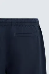 Pantalón azul marino de corte recto, con cintura elástica ajustable con cordón, bolsillos laterales y traseros.