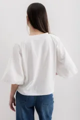 Blusa blanca de algodón con mangas abullonadas con bordado calado.