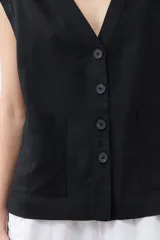 Chaleco negro con cuello en V y cierre frontal con botones. Confeccionado en lino.