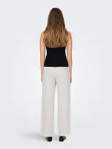 Top negro tejido de punto plano, sin mangas y con cuello redondo. Diseño flexible y cómodo.