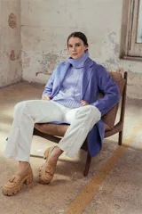 Mocasines color beige con plataforma y detalle de borlas en la parte delantera.