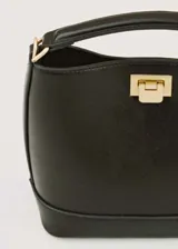 Bolso tipo bucket negro con asa corta y cierre metálico dorado.