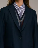 Blazer azul de corte medio largo, con cuello italiano, solapa de muesca, cierre frontal con un botón y bolsillos con solapa.