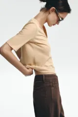 Camiseta color beige de lino con cuello en V y mangas cortas.