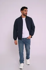 Campera bomber color azul marino, con cuello y puños acanalados, y cierres metálicos.