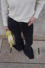 Pantalón de jean negro de corte recto y tiro alto, con bolsillos delanteros y traseros.