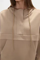 Buzo negro con capucha, cuello alto con broches, manga larga y bolsillo canguro frontal.