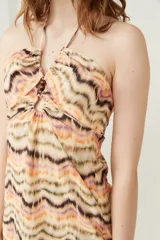 Minivestido con estampado zig-zag en tonos beige, naranja y marrón, con escote halter y espalda descubierta.