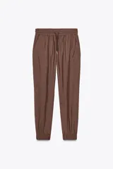 Pantalón jogger marrón de tiro alto con cintura elástica ajustable con cordones, bolsillos delanteros y puños elásticos en los tobillos.