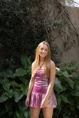 Vestido corto con estampado de rayas horizontales en tonos grises y negros. Diseño con escote halter que se ata al cuello, abertura central en el busto y falda corta con volado.