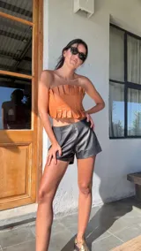 Top strapless de cuero negro con tablitas y elástico en la espalda.