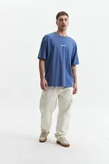 Remera azul de corte holgado con estampa en la espalda de una galleta y un cartón de leche con el texto "Cookies & Milk".