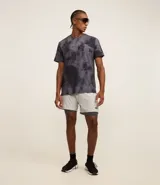 Remera deportiva negra con estampado manchado en gris y lettering en el pecho. Confeccionada en tejido dry de poliéster y elastano, con cuello redondo y mangas cortas.