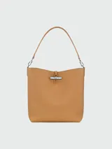Bolso tipo hobo de cuero color negro, con asa de hombro ajustable y cierre superior con broche metálico.