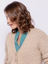 Cardigan corto de punto color beige, con diseño de tramado, escote en V y cinco botones.