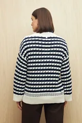 Sweater tejido de algodón color crudo con rayas horizontales azul marino y diseño calado.