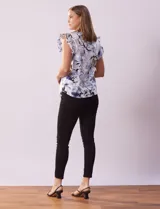 Blusa de algodón estampada con flores en tonos celeste y azul, cuello mao, escote en V, abertura frontal con botones y volados en las sisas.