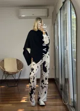 Pantalón largo de lanilla color crema con estampado de manchas de vaca en negro, corte recto y cintura con cordón ajustable.