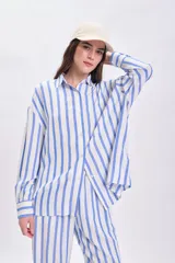 Camisa celeste y blanca a rayas verticales, de corte holgado y manga larga.