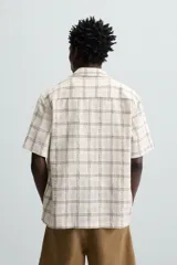 Camisa de manga corta con cuello bowling y corte relaxed fit, confeccionada en tejido con mezcla de algodón y estampado a cuadros.
