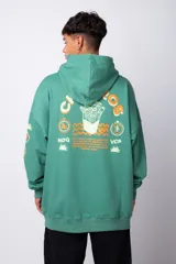 Buzo canguro gris claro de corte oversize, con capucha y cordones negros con letras blancas. Presenta un bolsillo tipo canguro y un estampado pequeño en el pecho y otro en la manga.