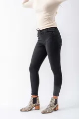 Pantalón de jeans negro con roturas, tiro alto, corte chupín y cintura elastizada con cordón ajustable.