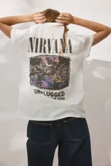 Remera blanca de corte amplio con cuello redondo y mangas cortas. Estampado frontal con el logo de Nirvana y la leyenda "Unplugged in New York".