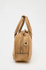 Bolso mini marrón de serraje con estilo bowling, doble asa corta y correa bandolera extraíble. Tiene pespuntes en el cuerpo, bolsillo interior con cremallera y cierre con cremallera.