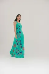Vestido largo color verde agua con estampado de flores azules y rojas.