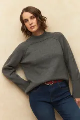 Polera de cuello alto, en color gris, con costuras tipo manga ranglan y diseño relajado.