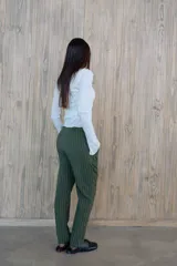 Pantalón verde con finas rayas verticales blancas, corte recto, tiro alto y bolsillos laterales.