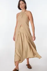 Conjunto de top halter con abertura en el abdomen y falda cruzada con ruedo desflecado, color fucsia.