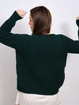 Cardigan marrón de punto grueso con cuello en V, cierre frontal con botones y parche bordado en el pecho.